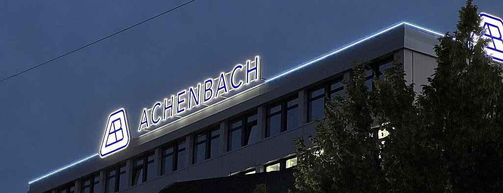 Unternehmensgebäude von Achenbach Buschhütten mit beleuchteter Schrift