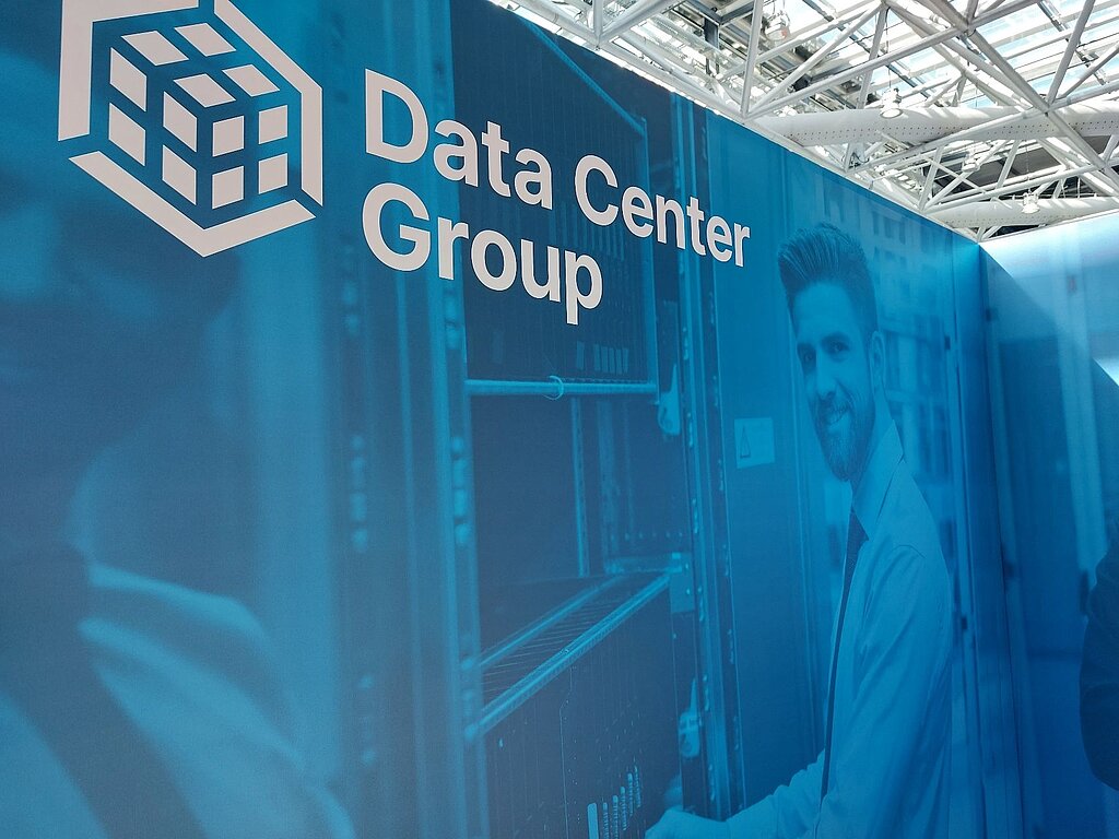 Wall showing Data Center Group and the DCG logo and a man, in blue