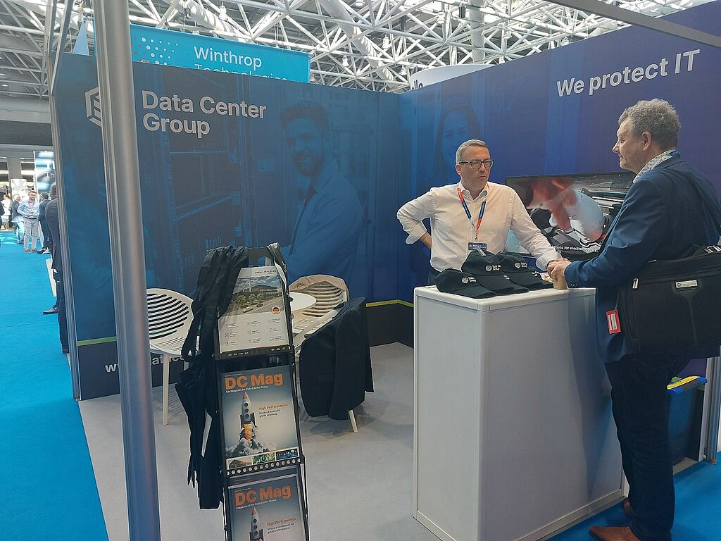 The Data Center Group booth at the Monaco show, Jörgen Venot talks to a man