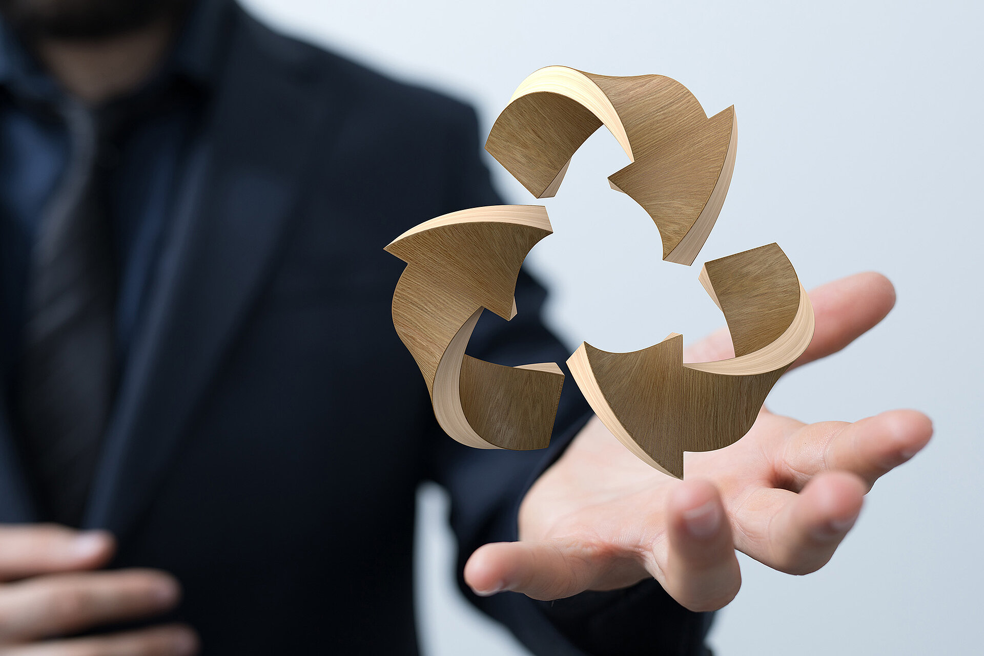 Ein Mann hält eine Visualisierung in der Hand, die 3 Pfeile aus Holz darstellt