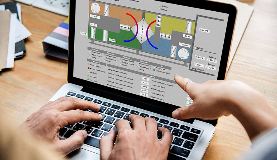 2 Menschen arbeiten an einem Laptop an einem Programm. Die linke Person tippt etwas auf dem Laptop ein, die rechte Person zeigt auf den Laptop