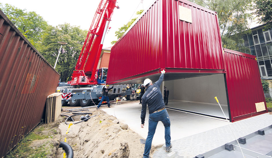 Impression einer Verladung eines DC IT Containers. Zweifachverkettung. 2 Techniker helfen beim Herab lassen