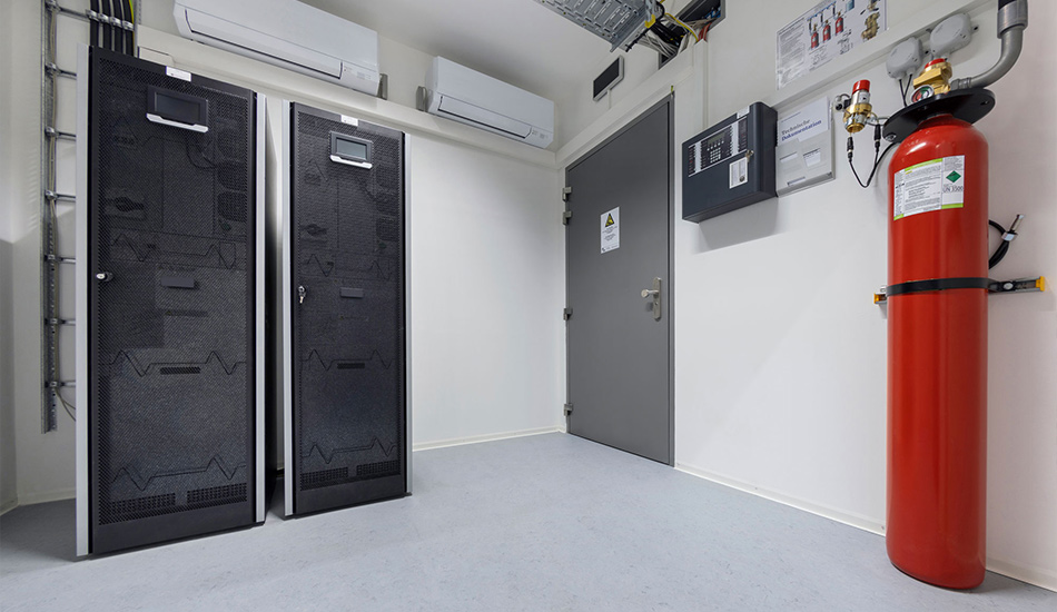 2 Plug and Play Container in Schwarz. Daneben Sicherheitstür, Messgeräte und ein Feuerlöscher