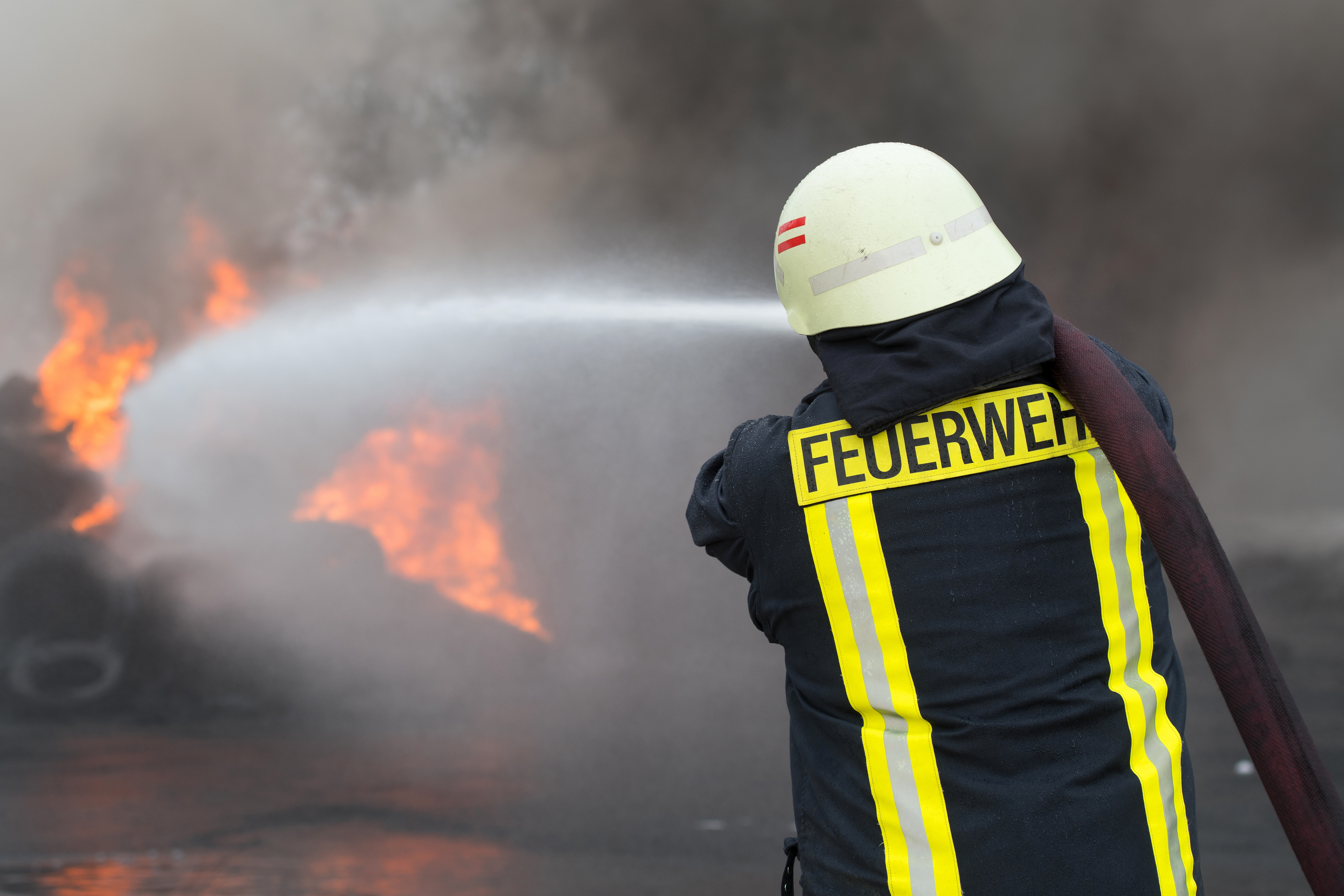 Feuerwehrmann beim Löschvorgang eines Feuers